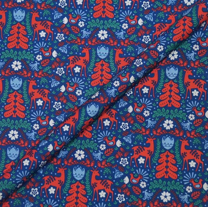 Patterned fabric with red deer, blue trees, and green leaves on a blue background